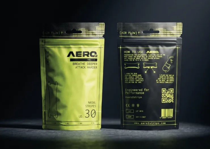 Two AERO2 pouches standing side by side in a dark studio, showing the volt green front panel and the black back panel