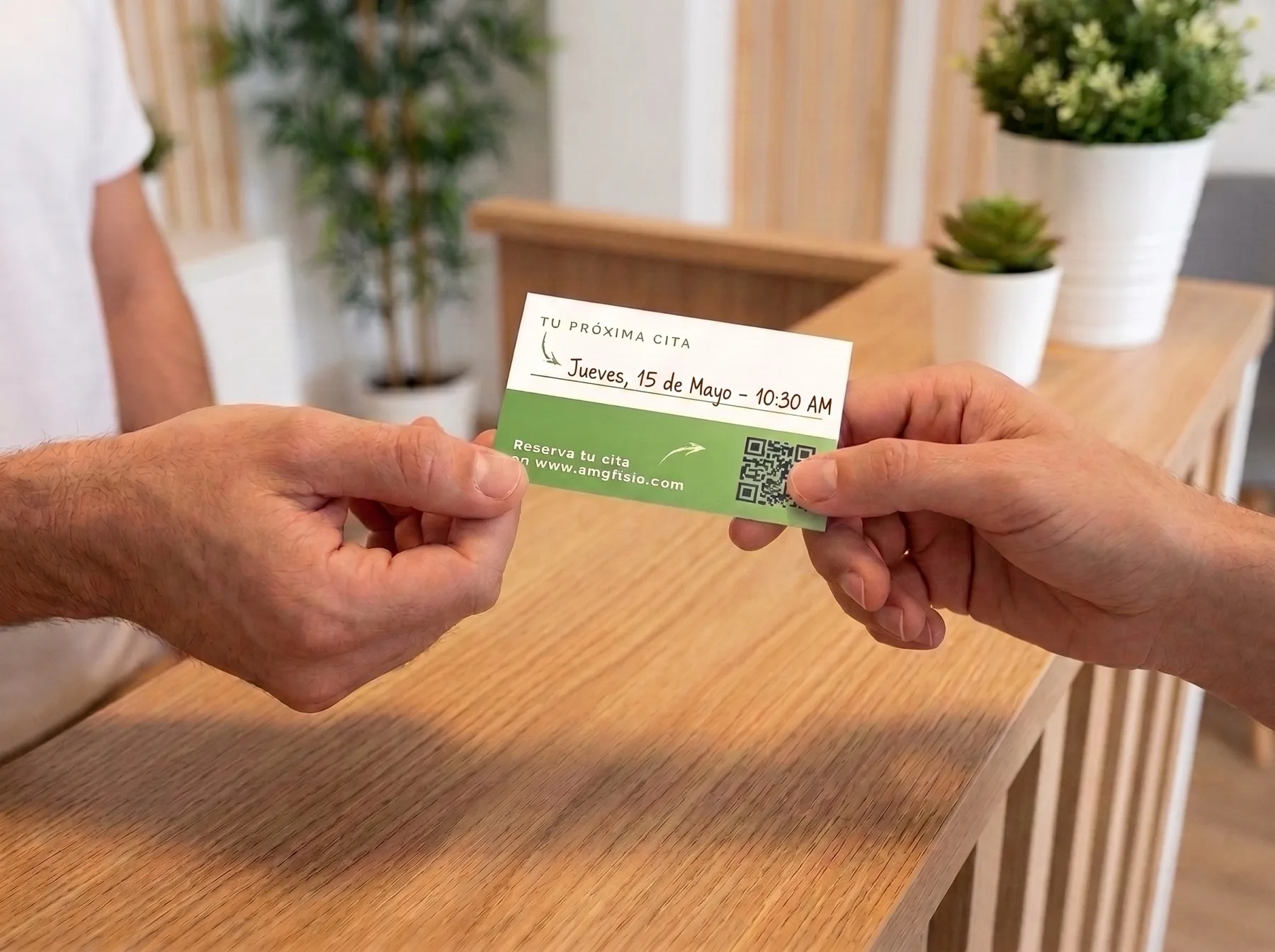 Mockup: a physiotherapist hands a patient a card at the reception desk, the green reverse showing a handwritten next appointment and the QR code