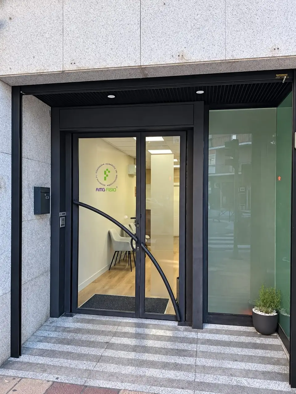 Entrance door of AMG Fisio with the round clinic decal