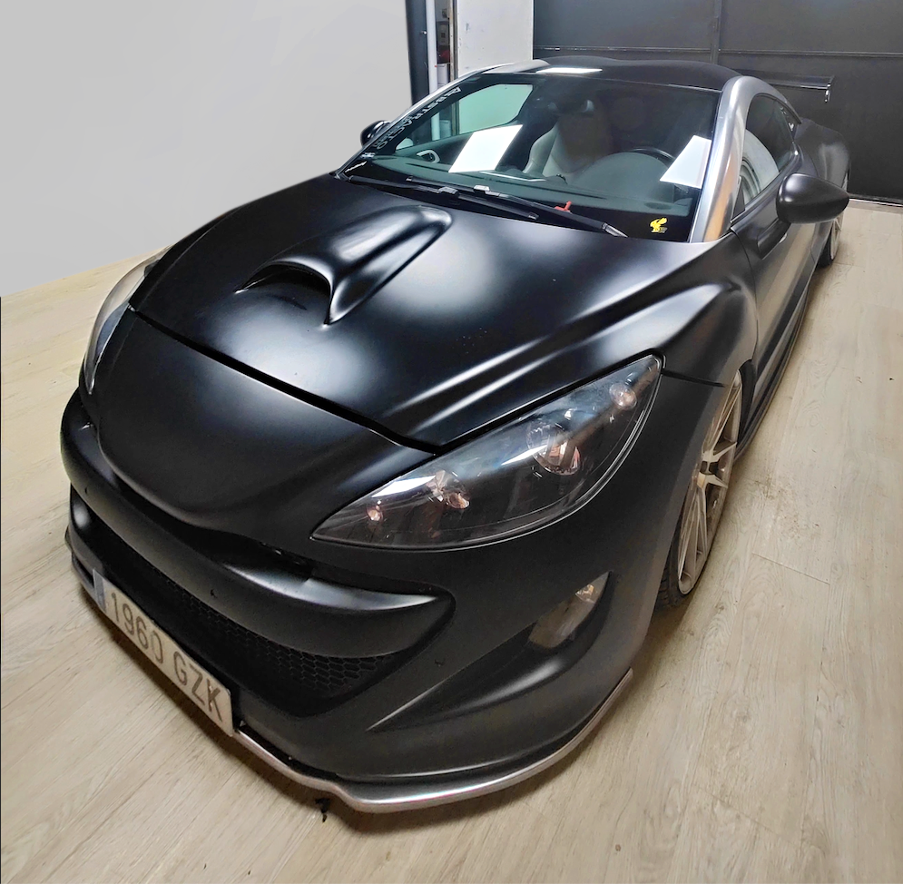 The actual client Peugeot RCZ with full widebody kit and rear spoiler, black, before the vinyl wrap