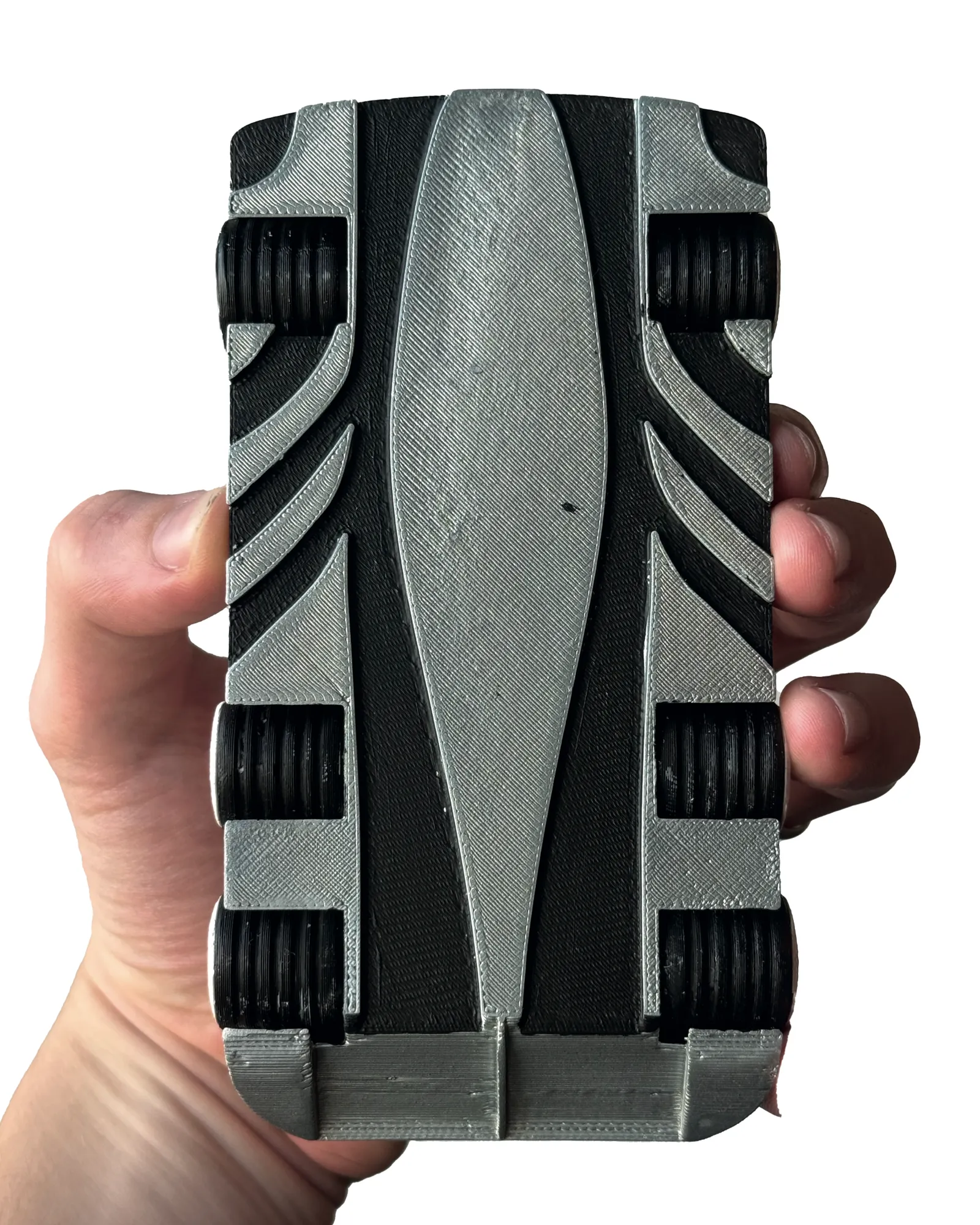 Underside of the printed car held in hand: chassis with layered surface and six black tyres