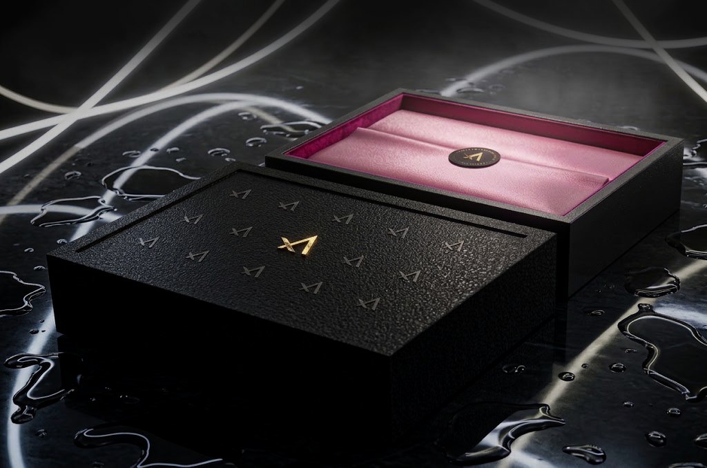 VELOQUE primary packaging box, matte black board with the debossed wordmark