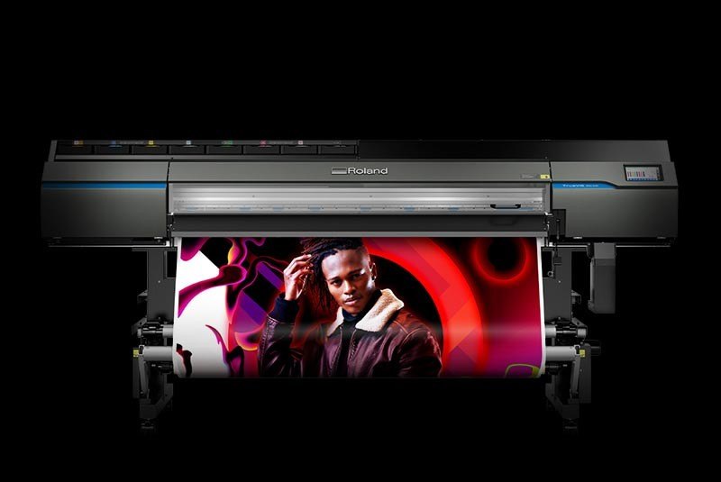 Roland TrueVIS wide-format eco-solvent printer running a printed panel, the machine used for VELOQUE graphics