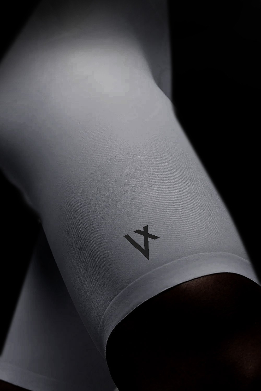 Leg hem of a VELOQUE bib short holding the thigh without a silicone gripper band, embossed V mark on the panel